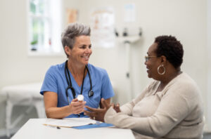 A female nurse advises her patient on treatment options in the doctor's office.