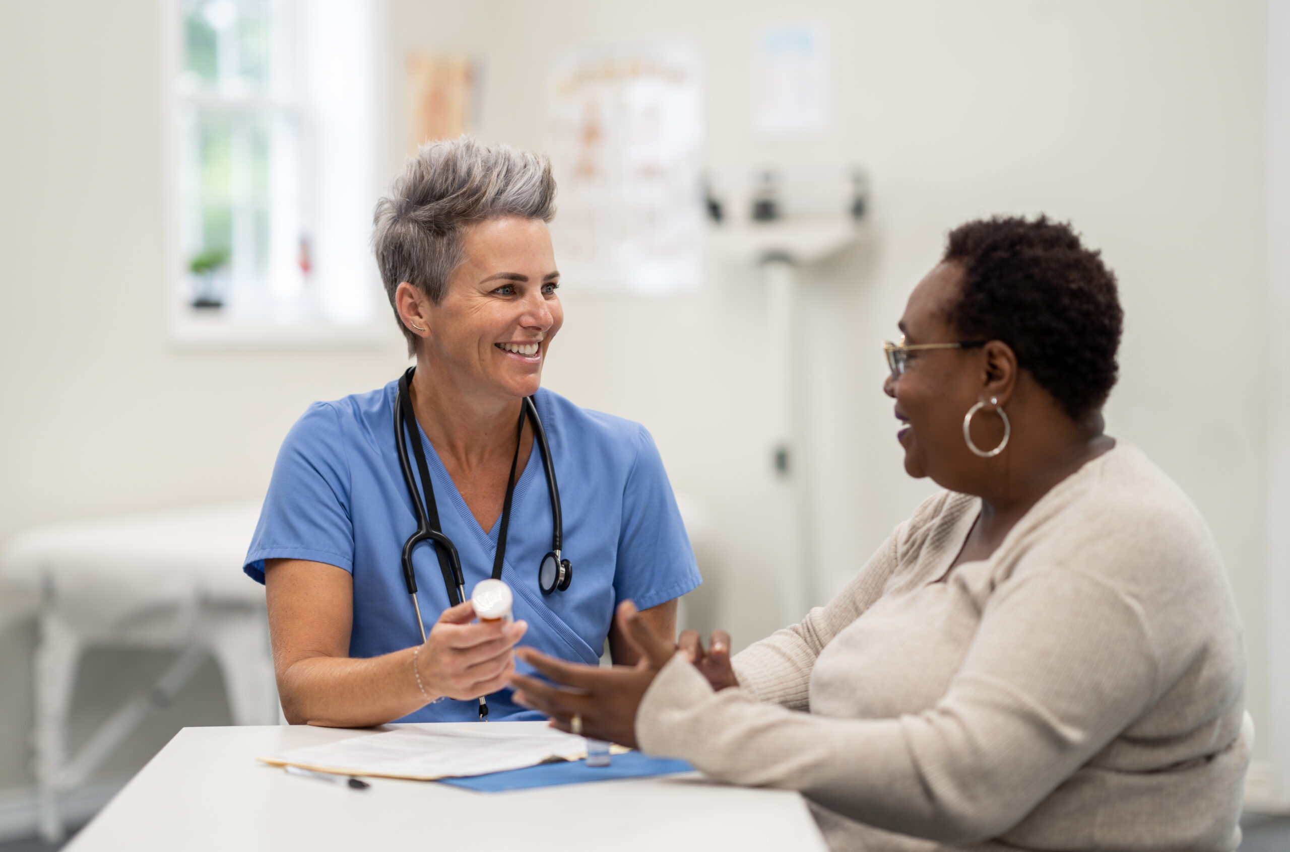 A female nurse advises her patient on treatment options in the doctor's office.