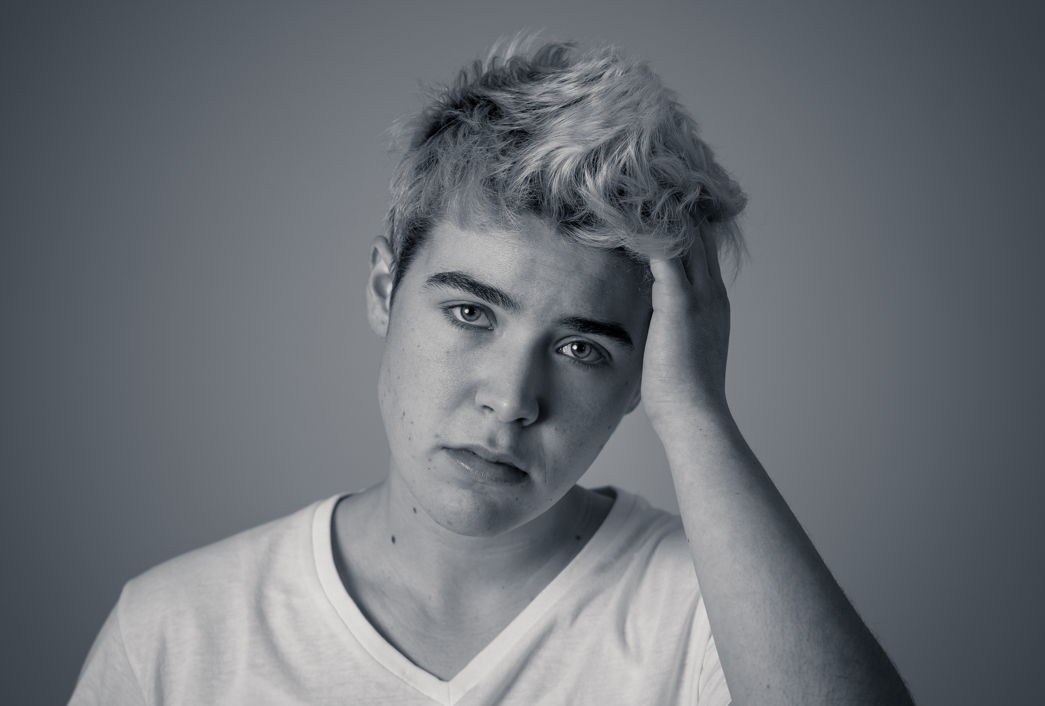 Young sad trans teenager boy suffering from depression feeling sad and desperate. Depressed transgender teen in distress In Mental health, Depression and gender identity and human rights concept.