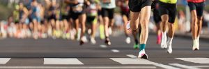 Marathon runners running on city road, large group of runners, close-up legs runners running sport marathon, male jogging race in asphalt road, athletics competition